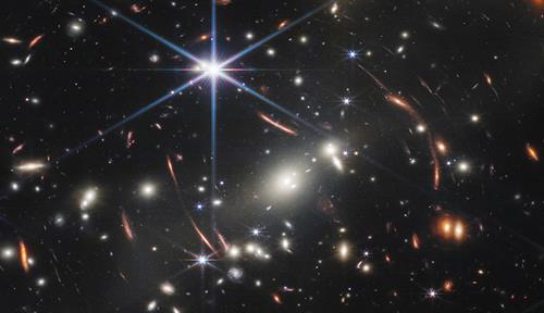 Miles de galaxias brillantes son visibles en la oscuridad del espacio en una imagen procesada captada originalmente con una cámara de infrarrojo cercano enfocada al cúmulo de galaxias SMACS 0723.