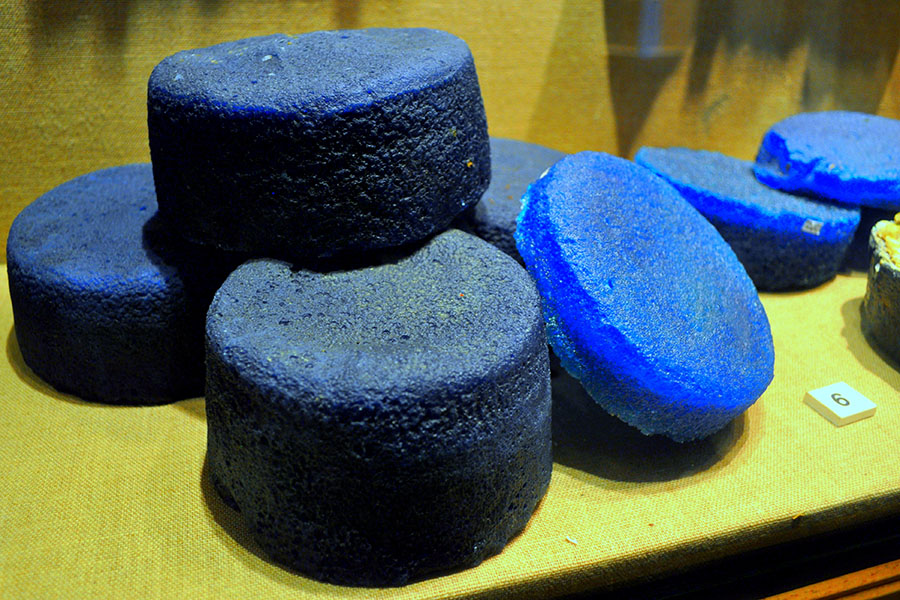 Fotografía de unos siete discos de vidrio gordos y azules, amontonados en una pila.
