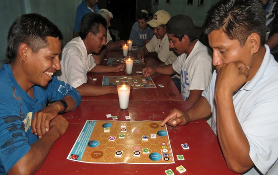 Hombres sentados en una hilera de mesas jugando un juego de tablero.