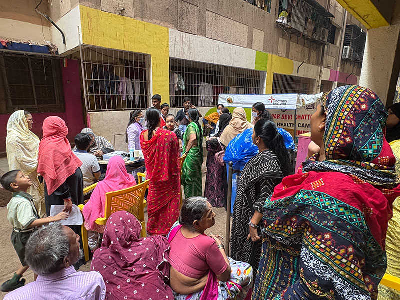 Un grupo de mujeres con coloridos saris en un callejón.