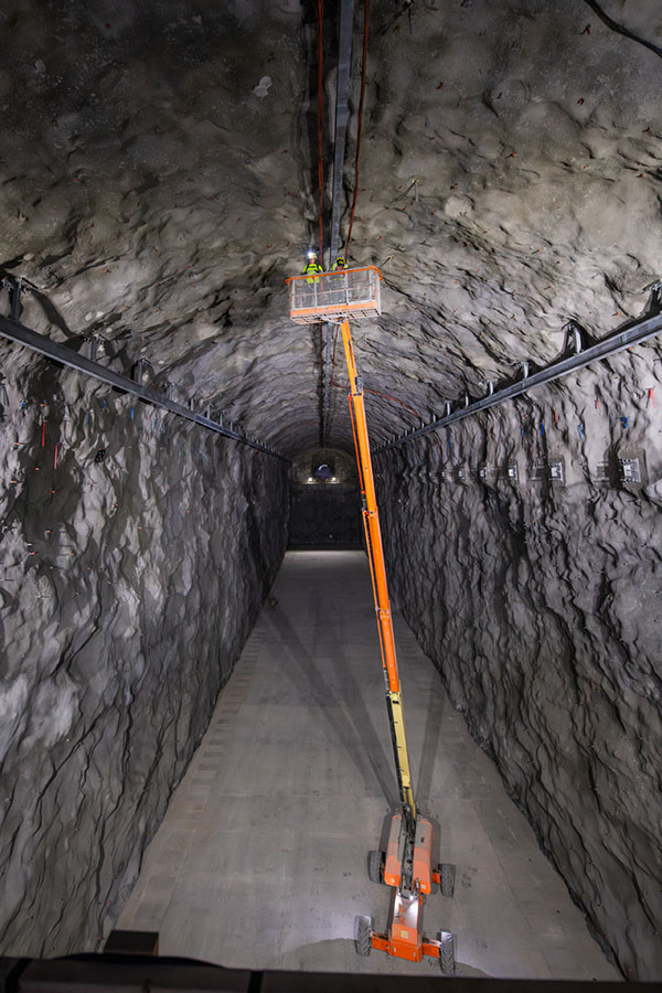 Laboratorio subterráneo Trabajadores en una grúa inspeccionan las paredes de un gran túnel.