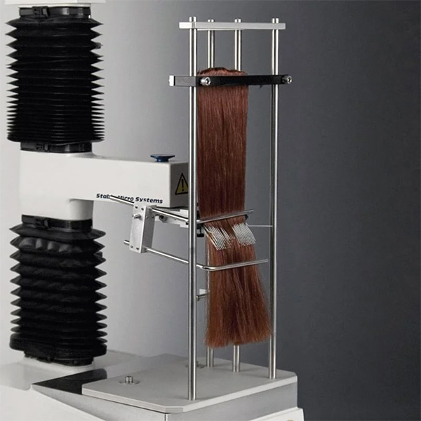 Fuerza para peinar el cabello Dispositivo que mide la fuerza necesaria para peinar una masa de cabello sujeta con una pinza.
