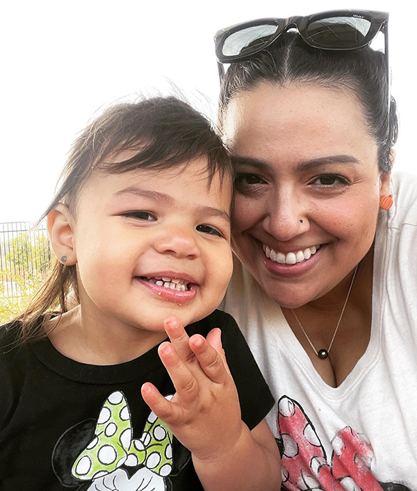Lisette López-Rose Foto de una mujer y su hija pequeña, ambas sonriendo alegremente.