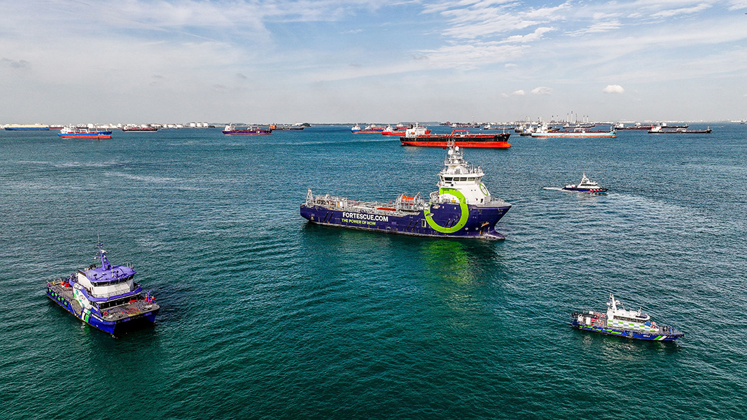 Foto de una variedad de embarcaciones amarradas en un puerto. Cerca del frente hay un barco que dice “fortescue.com, el poder del ahora” en su costado.