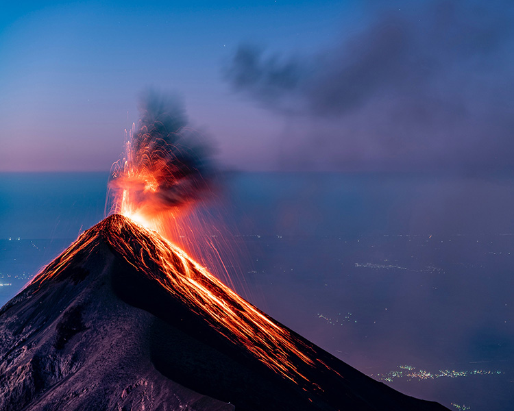 Un volcán en erupción, con lava que sale a chorros de su cráter.