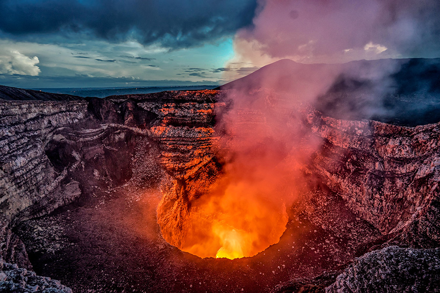 Cráter de un volcán en el que se ve la lava incandescente. 