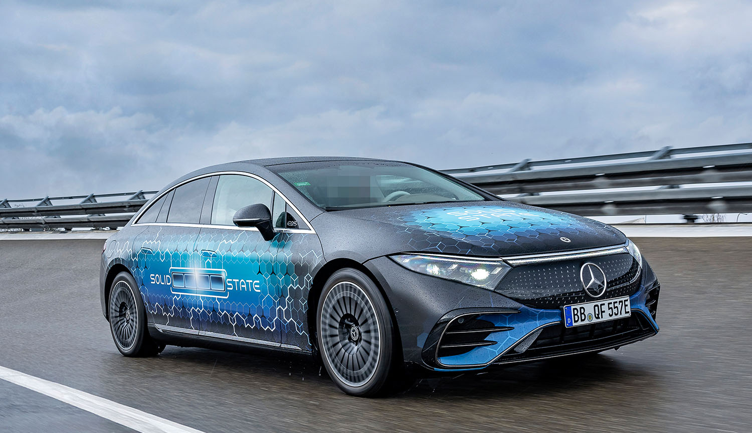 Foto de febrero de 2025 que muestra un vehículo Mercedes-Benz circulando por un circuito en un día nublado. El vehículo está cubierto con un diseño que muestra una batería en carga y las palabras “Solid State” (estado sólido).